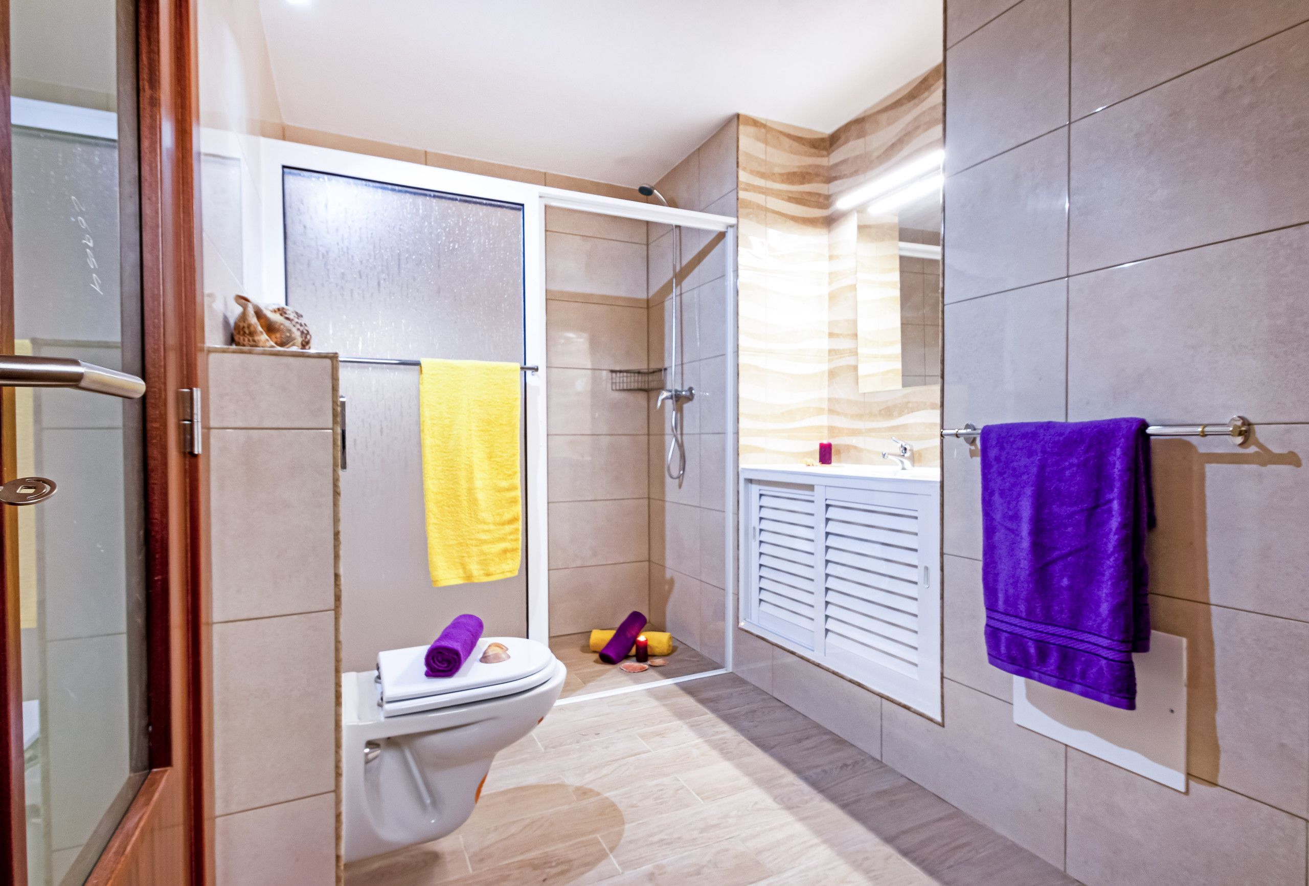 A modern bathroom with a shower, toilet, and sink.