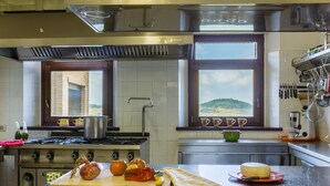 Una cocina con estufa a gas, horno y un amplio ventanal con vistas al paisaje.