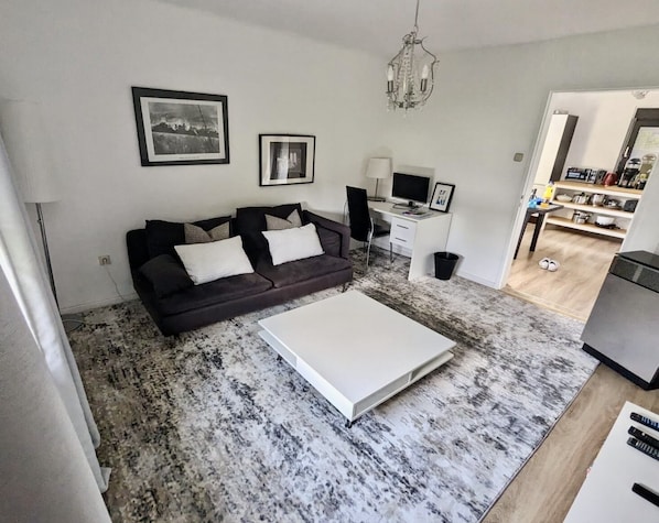 Relax in this stylish living room with a sofa, coffee table, and desk, perfect for working or unwinding.
