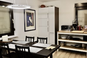 Enjoy meals at the dining table with four chairs, surrounded by modern kitchen appliances and a stylish countertop.