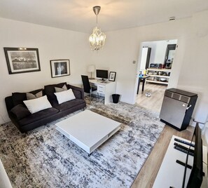 Relax in this stylish living space with a sofa, coffee table, and desk, perfect for working or unwinding.