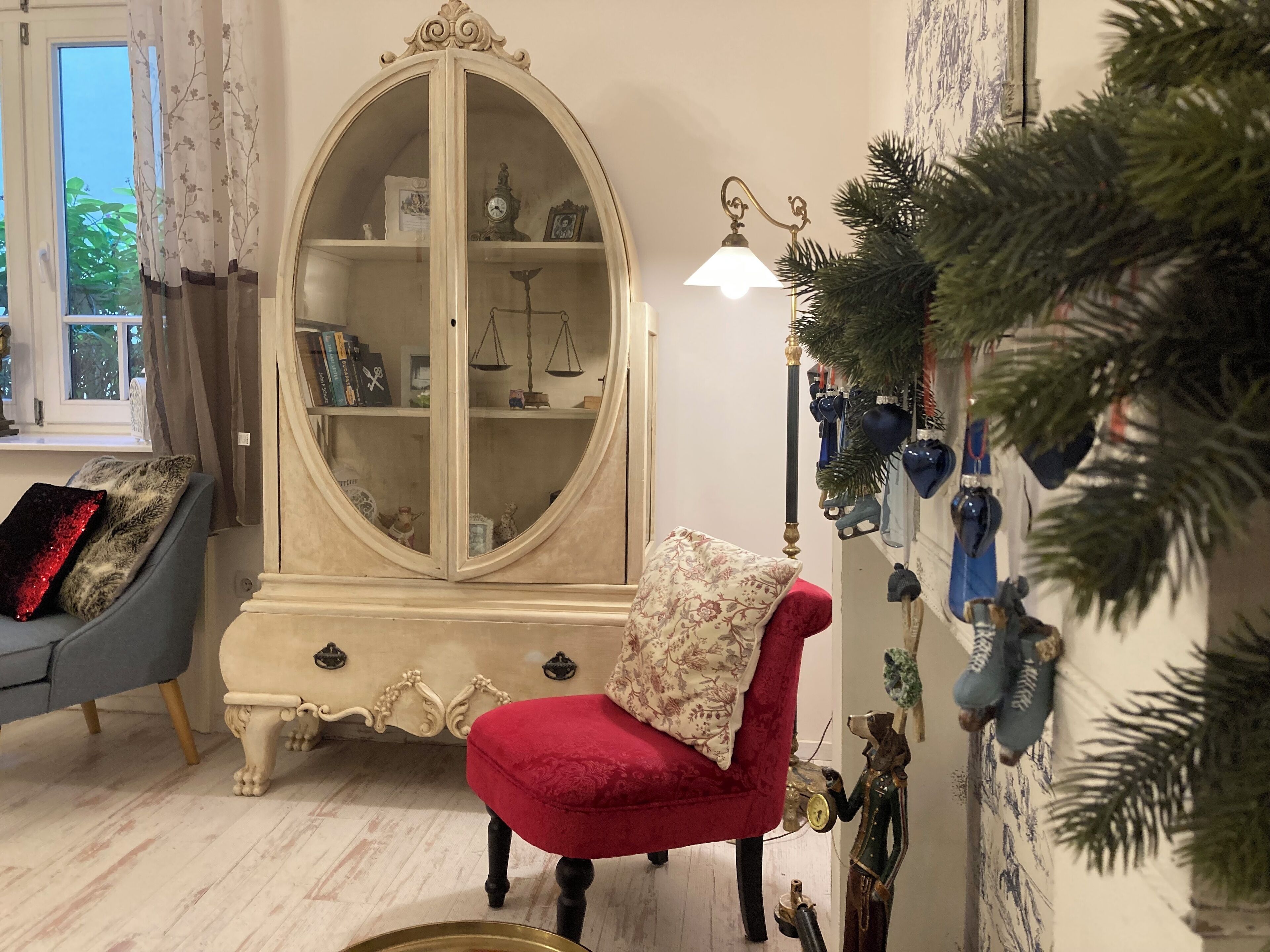 Una sala de estar con un sillón rojo, un armario blanco y un sillón azul.