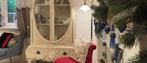 Una sala de estar con un sillón rojo, un armario blanco y un sillón azul.