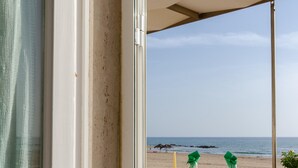 A terrace with a table set for dining, overlooking a beach. - Small, modern beach house on the sand, quiet,sea view, WiFi, aircon, max. 7 p. (Donnalucata)
