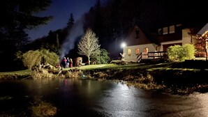 A nighttime scene by a pond with a building in the background. - Ferienhaus Oppach (Oppach)