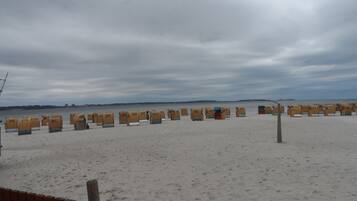 Ein Strand mit Reihen nummerierter Strandkörbe.