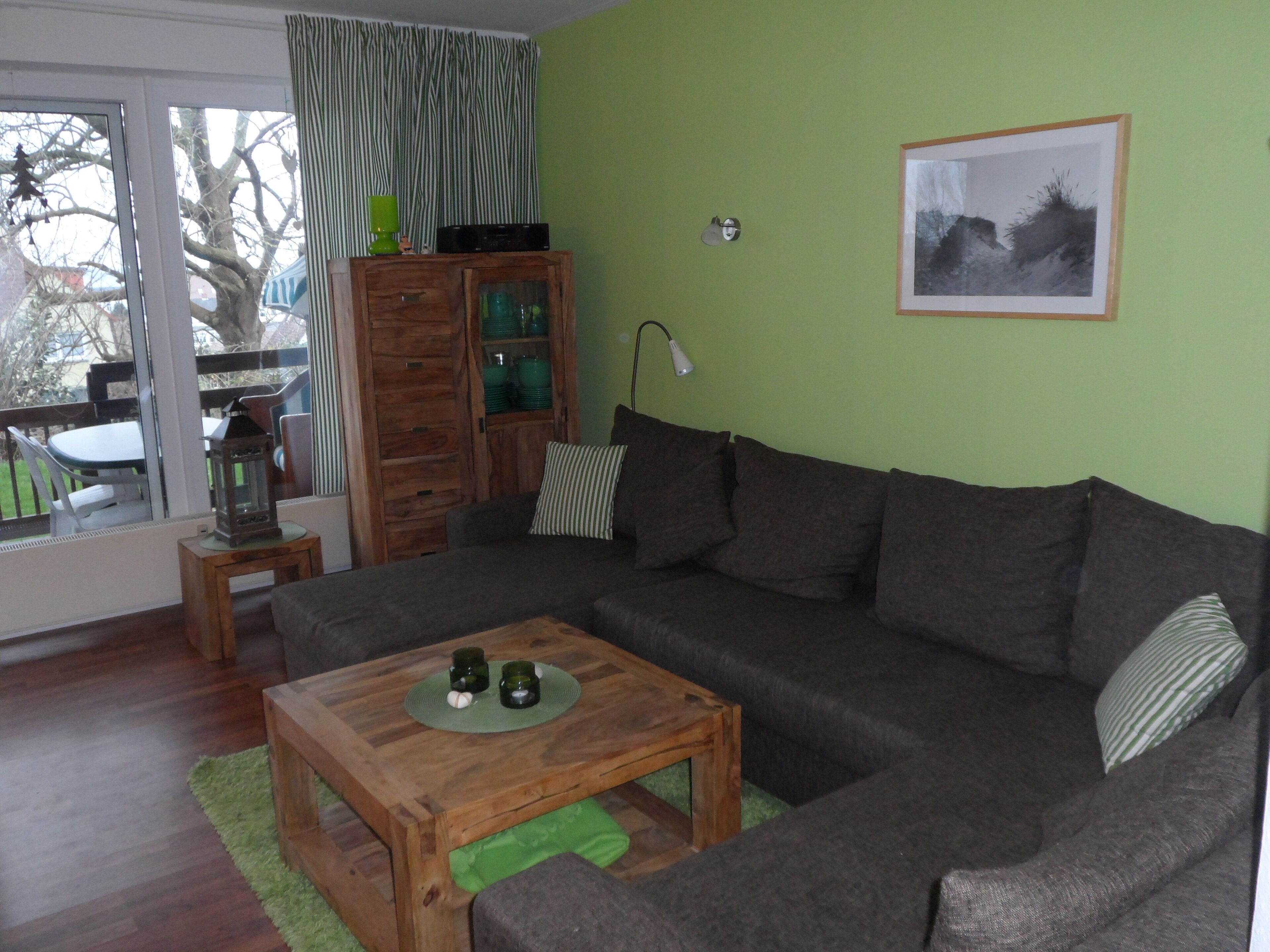 A living room with a wooden coffee table, a sofa, and a cabinet with glass doors.