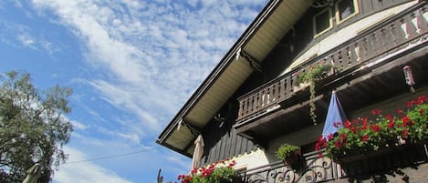 Un edificio tradicional con balcones, algunos adornados con macetas de flores.