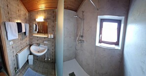 Een douche, handdoeken, zeep, toiletpapier