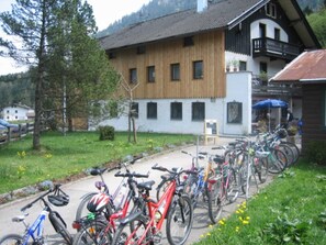 Una fila di biciclette parcheggiate di fronte a un edificio con facciata in legno e un balcone.