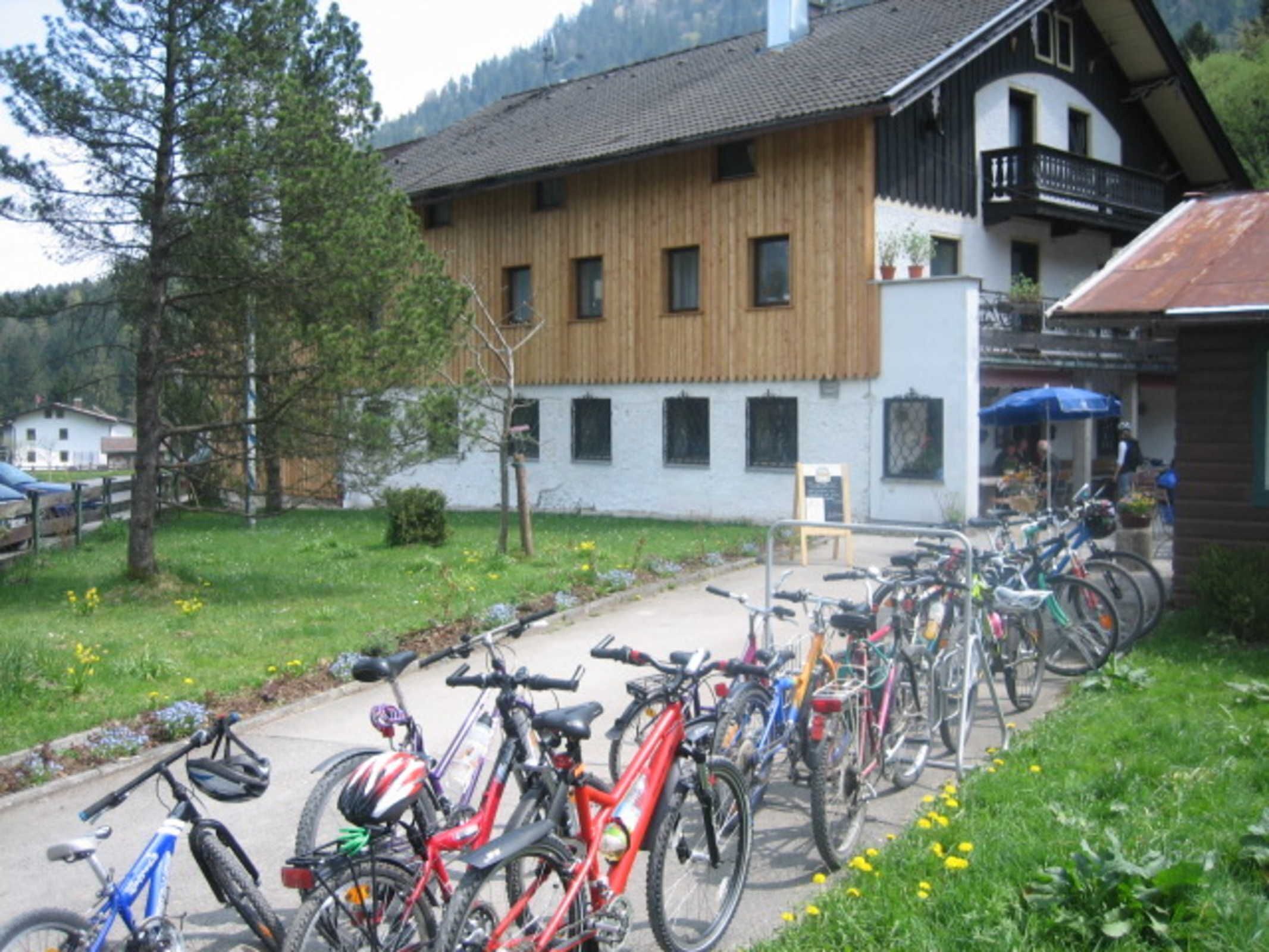 Eine Reihe von Fahrrädern vor einem Gebäude mit Holzfassade und Balkon.