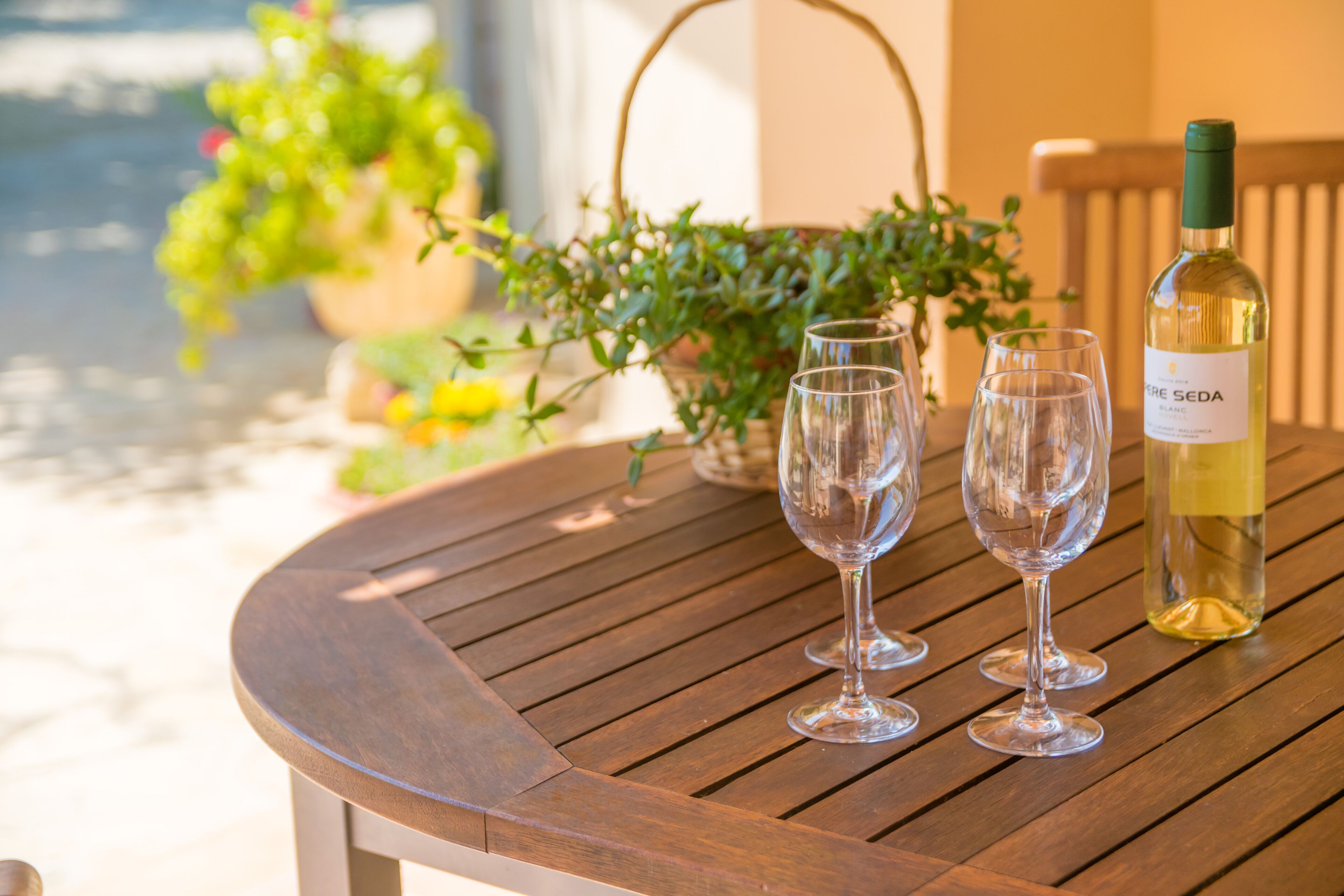 A wooden table with three wine glasses and a bottle of wine.