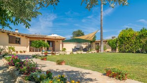 A residential property with a paved patio, a lawn, and potted plants. - Holiday house with pool in the heart of Mallorca (Sant Joan)