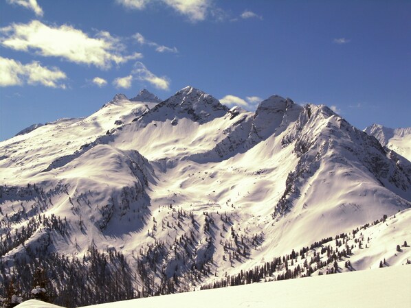 Une chaîne de montagnes enneigée sous un ciel dégagé.