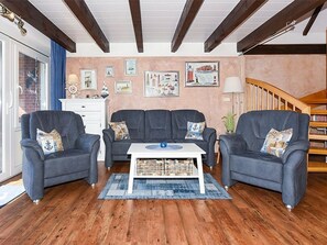 Ein Wohnzimmer mit zwei Sofas, einem Couchtisch und einer Treppe.