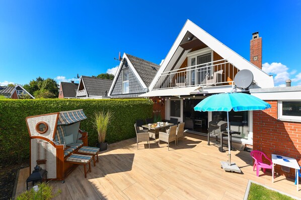 A house with a patio, outdoor furniture, and a satellite dish.