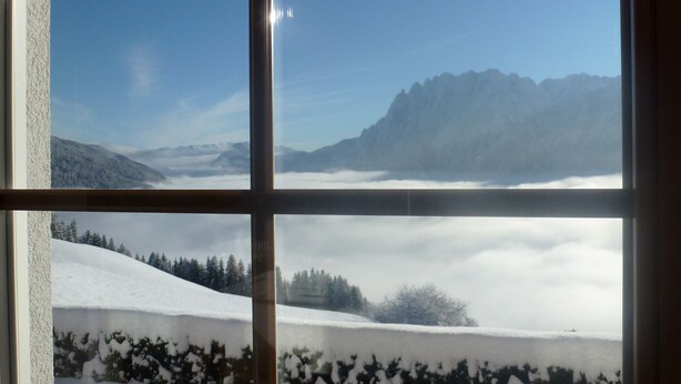 Una ventana con vistas a un paisaje nevado y montañas.