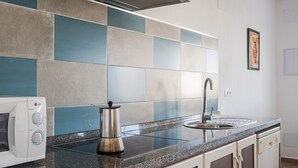 A kitchen with a microwave, kettle, sink, and tiled backsplash. - Holiday Home 'Villa Charco del Sultán' with Wi-Fi, Pool, Terrace & Garden (Conil de la Frontera)