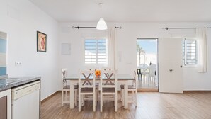 A dining area with a table and chairs, a pendant light, and a view through an open door. - Holiday Home 'Villa Charco del Sultán' with Wi-Fi, Pool, Terrace & Garden (Conil de la Frontera)