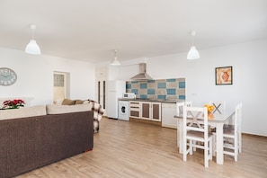 A modern kitchen with a microwave, washing machine, and a tiled backsplash.