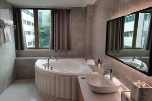 A modern bathroom with a freestanding bathtub, a vanity with a bowl sink, and a large mirror. - Changhong International Hotel (Mianyang)