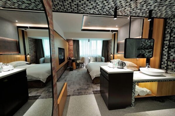 A hotel room with a bed, bedside tables, a desk, a sink, and a mirror. - Changhong International Hotel (Mianyang)