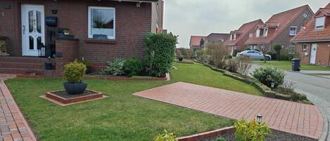 Un barrio residencial con casas de ladrillo, jardines cuidados y un camino de entrada pavimentado.