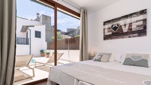 A bedroom with a bed, a view of the outside, and a 'LOVE' sign on the wall. - Can Xisco (Sineu)