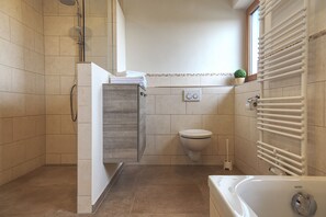 Bathtub, rainfall showerhead, hair dryer, towels