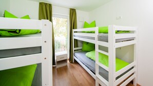 A room with bunk beds, a window with curtains, and a small desk. - 5 large apartments, for a maximum of 4 people in an idyllic location near Munich (Billingsdorf)