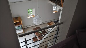 A modern kitchen with a dining area, a staircase, and a view of the outdoors. - Old forge in a listed courtyard (Messerich)