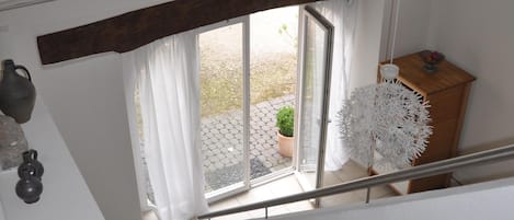 Eine Treppe führt zu einer zweiten Etage mit Blick auf einen Garten durch eine Glastür.