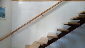 A wooden staircase with a simple design, a white radiator, and a framed picture on the wall. - Super idyllic vacation home with privacy to relax, WiFi included. (Jemgum)