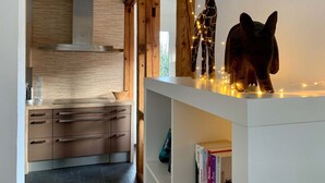 A modern kitchen with wooden cabinets, a white countertop, and a giraffe sculpture with lights. - Villa Landenberger Metzingen near Outlet City Apartment Annemarie (Metzingen)