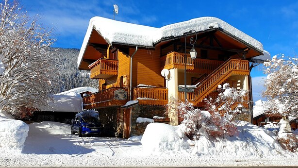 A wooden chalet with a balcony and a staircase, surrounded by snow-covered trees. - Châtel Portes du Soleil Free MultiPass 3-Star Apartment PDS Chairlifts 400 meters away (châtel)