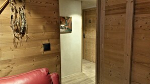 A wooden interior with a red leather bench, a wall-mounted dreamcatcher, and a framed picture. - Châtel Portes du Soleil Free MultiPass 3-Star Apartment PDS Chairlifts 400 meters away (châtel)