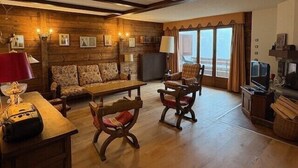 Una sala de estar acogedora con una pared de madera, un sofá, una mesa de centro y una chimenea.