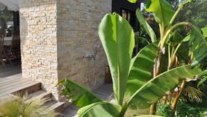 Un edifici de pedra amb una terrassa de fusta i una porta.