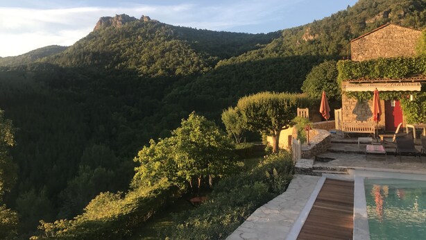 A hillside view with a pool area, stone building, and lush greenery. - House, St Rome de Cernon (St Rome de Cernon)