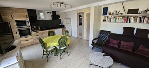 Um espaço compacto com cozinha, área de refeições e sala de estar.