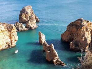A coastal landscape with rocky formations and clear turquoise water. - Historic Roof Top Olhão, 360° panoramic sea view. (Olhão)
