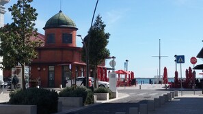 A coastal building with a dome, red umbrellas, and a pedestrian crossing sign. - Historic Roof Top Olhão, 360° panoramic sea view. (Olhão)