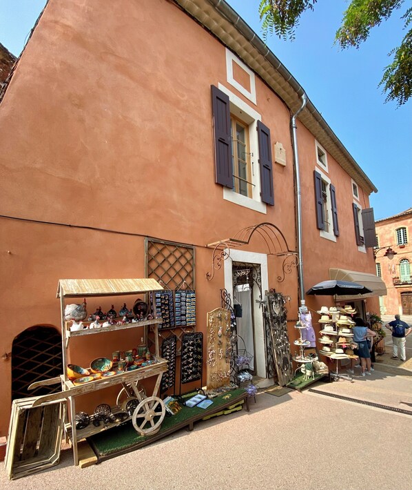 Un bâtiment rustique abritant une boutique où sont vendus divers articles, notamment des chapeaux et des bijoux.