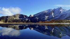 A mountain landscape with a clear reflection in a calm body of water.