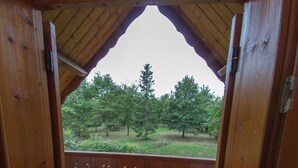 A wooden balcony with a view of a grassy area and trees. - Country cottage close to pond forest. Pets allowed (Souvigny-En-Sologne)