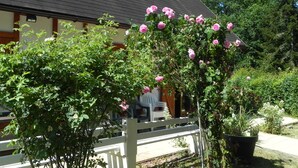 A building with a white fence and a garden with blooming pink roses. - Country cottage close to pond forest. Pets allowed (Souvigny-En-Sologne)