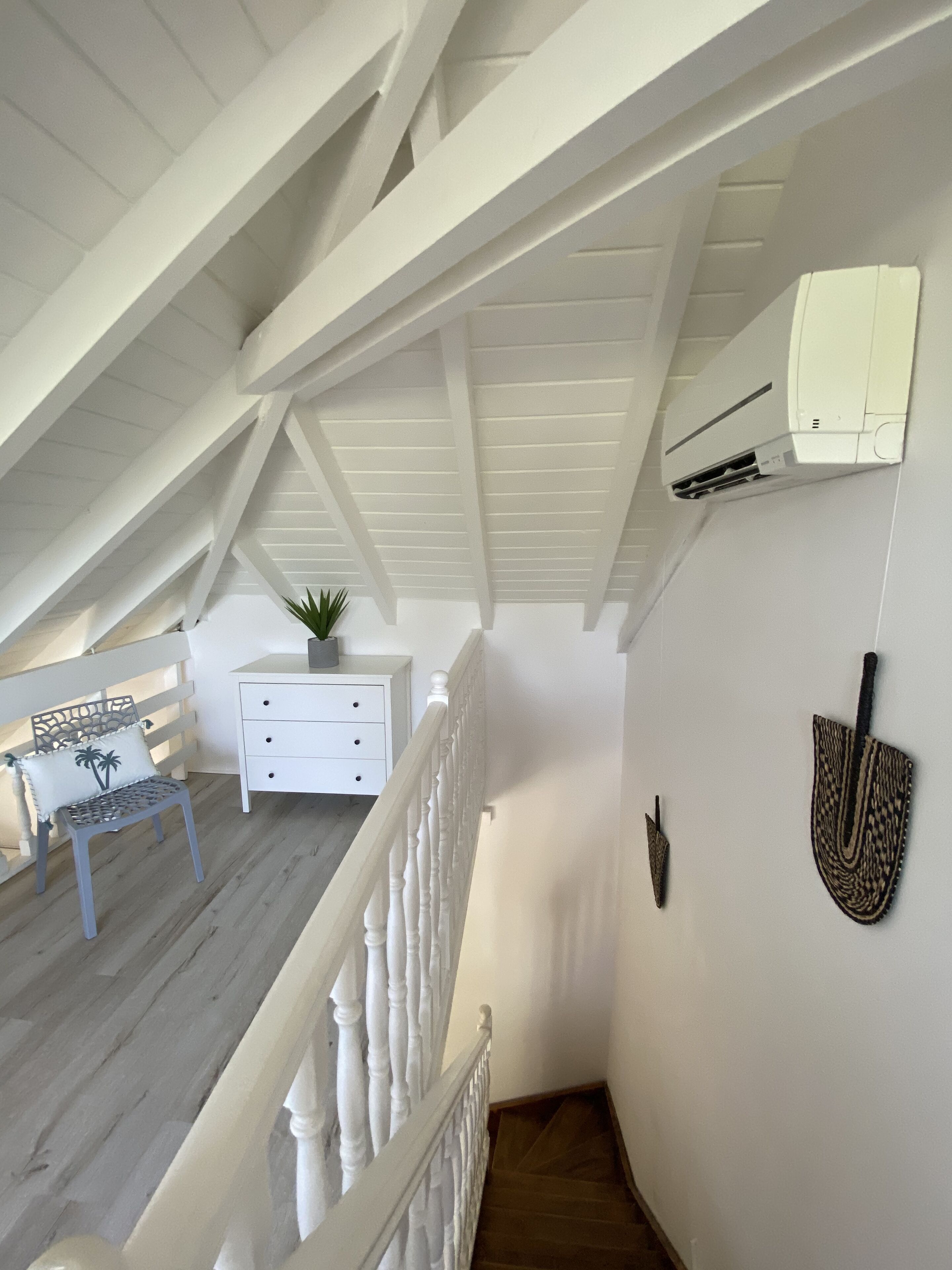 Un interior blanco con una escalera que sube a una zona superior.