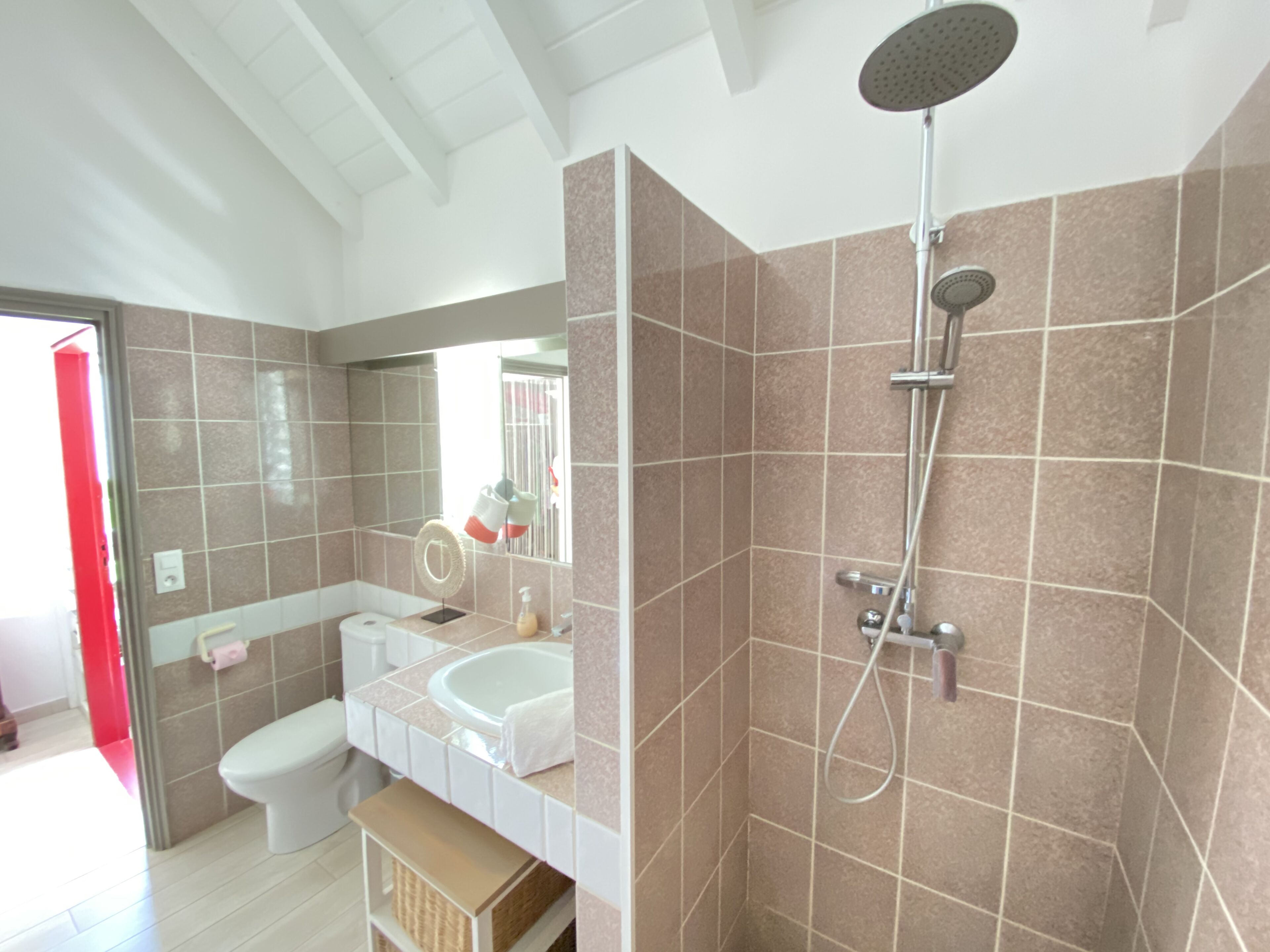 A modern bathroom with a shower, toilet, and sink.