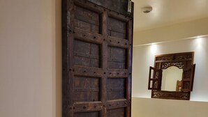 A room with a wooden sliding door, a small wooden stool, and a mirror on the wall. - In a quiet location between Aix and Marseille. Provence. Beach 10 km away, with no buildings directly across from the property  (Lançon-Provence)