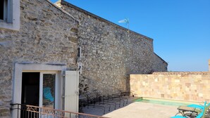 A stone building with a balcony, outdoor furniture, and a pool area. - In a quiet location between Aix and Marseille. Provence. Beach 10 km away, with no buildings directly across from the property  (Lançon-Provence)